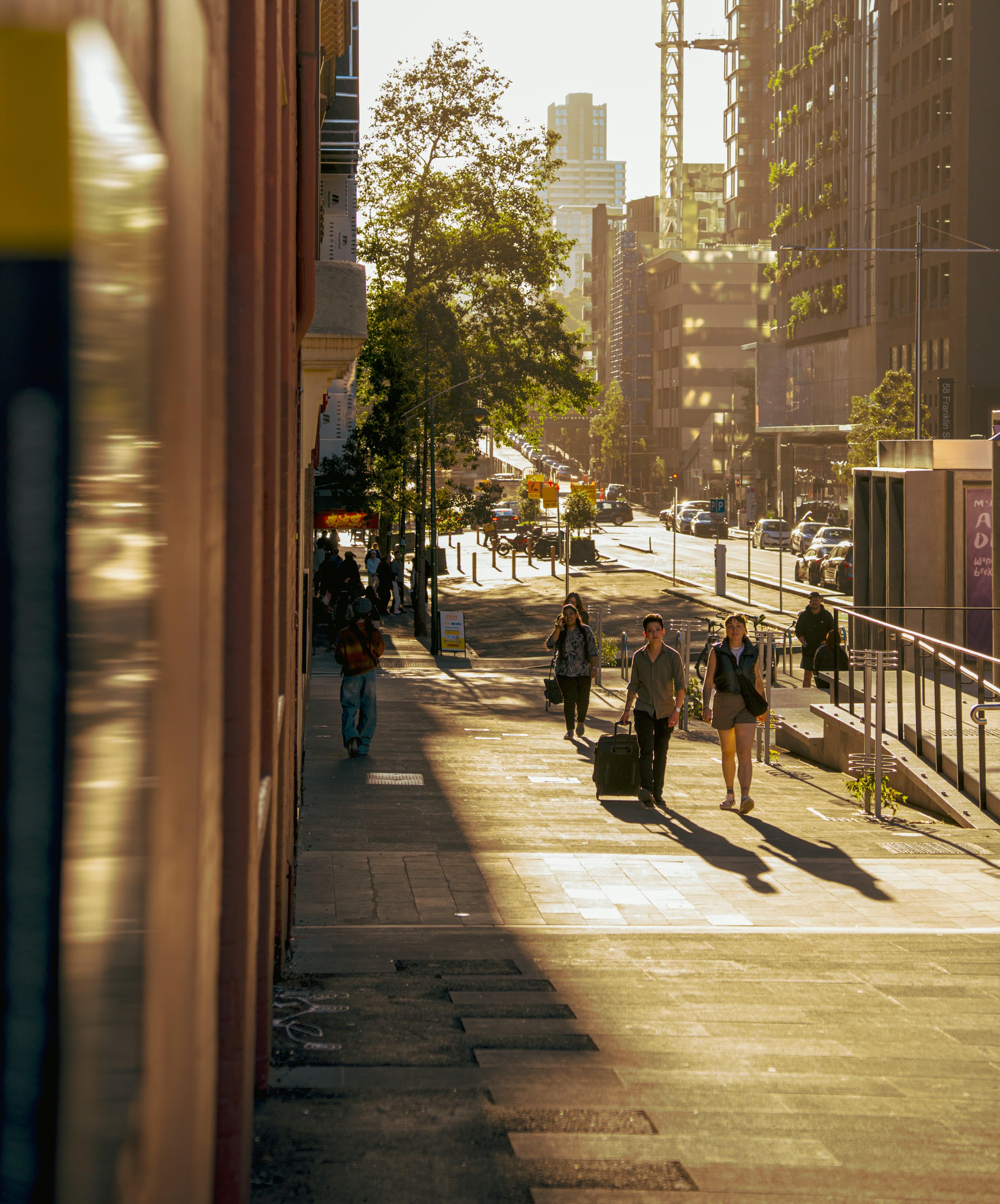 People walking through a sunlit city street